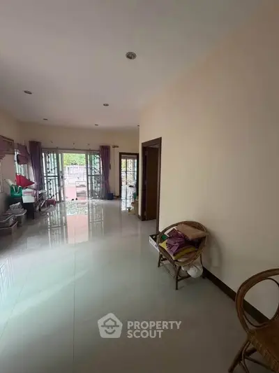 Spacious living room with large windows and garden view, perfect for family gatherings.
