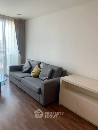 Modern living room with sleek sofa and natural light, perfect for relaxation.