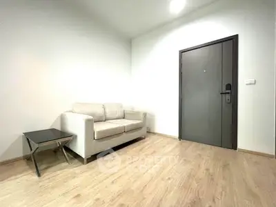 Modern minimalist living room with cozy sofa and sleek wooden flooring.