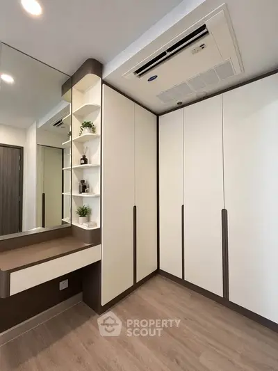 Modern bedroom with built-in wardrobe and sleek vanity in a stylish apartment.