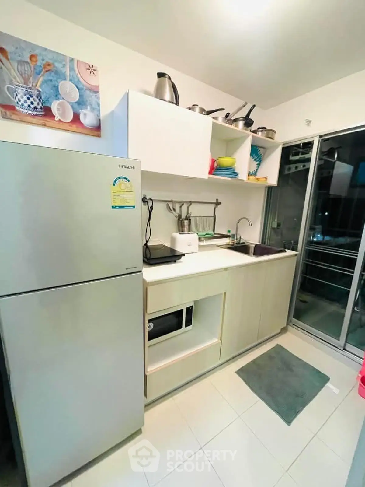 Modern compact kitchen with stainless steel fridge and open shelving