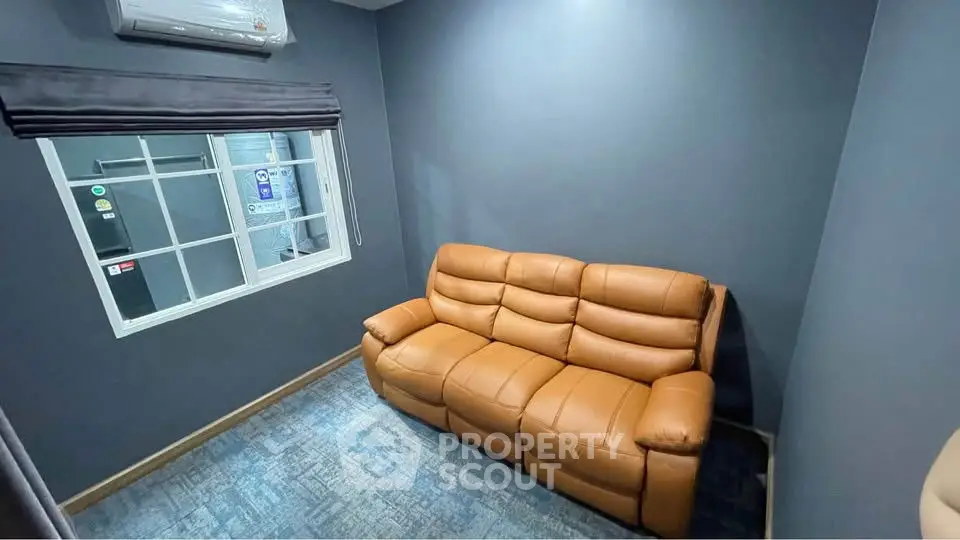 Cozy small living room with leather sofa and air conditioning