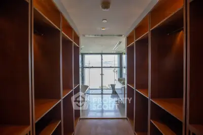 Luxurious walk-in closet leading to a modern bathroom with a bathtub and large window.