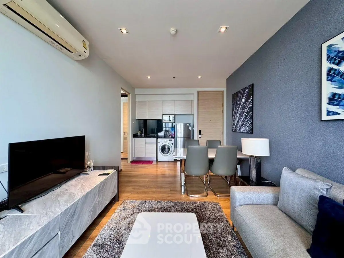 Modern living room with open kitchen and stylish decor in a cozy apartment.