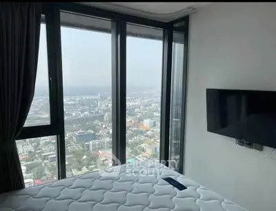 High-rise bedroom with stunning city view and wall-mounted TV
