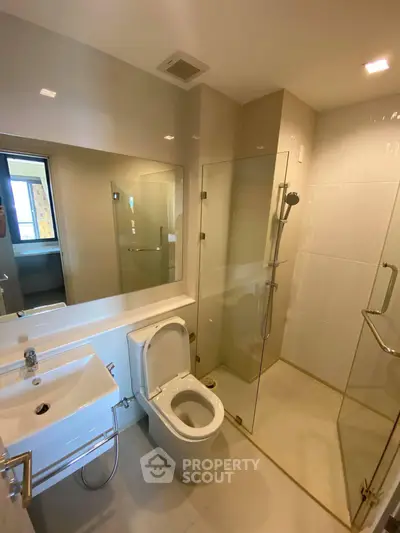 Modern bathroom with glass shower and sleek fixtures in a contemporary apartment.