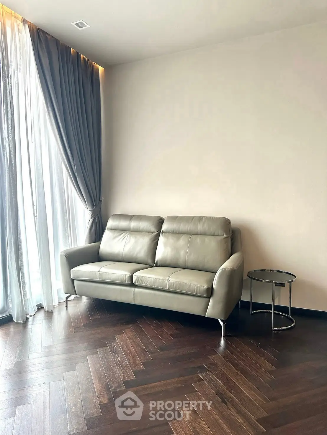 Modern living room with sleek leather sofa and elegant curtains