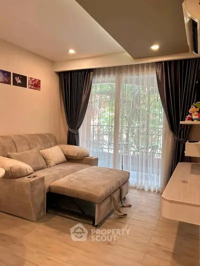 Cozy living room with plush sofa and elegant curtains, perfect for relaxation.