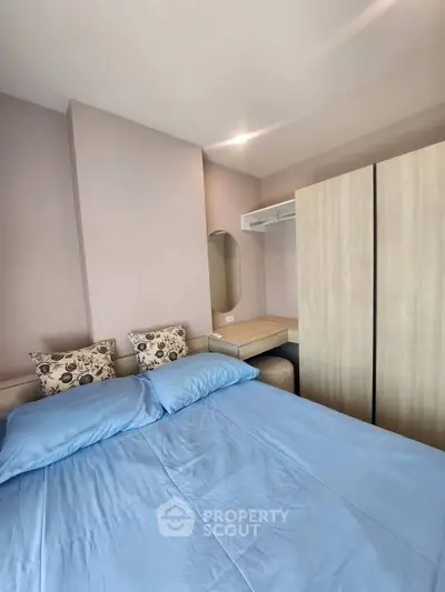 Cozy bedroom with blue bedding and modern wardrobe in stylish apartment