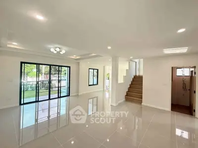 Spacious modern living room with large windows and glossy tile flooring