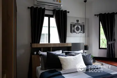 Cozy bedroom with modern decor, featuring a stylish bed, dark curtains, and a unique camera-themed wall art.