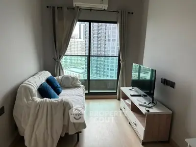 Cozy living room with city view, featuring a comfortable sofa and modern TV setup.