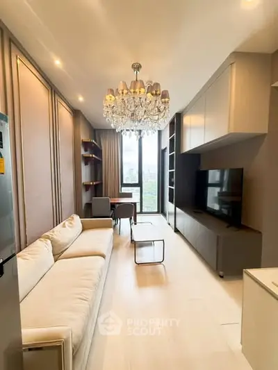 Luxurious modern living room with chandelier and city view, featuring elegant furnishings and natural light.