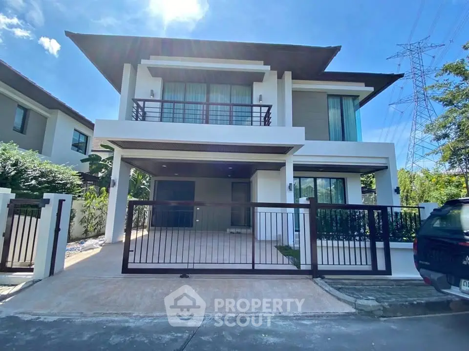 Modern two-story house with spacious driveway and balcony in a serene neighborhood.