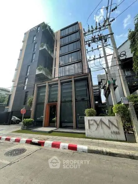 Modern urban building exterior with sleek design and lush greenery, perfect for contemporary living.