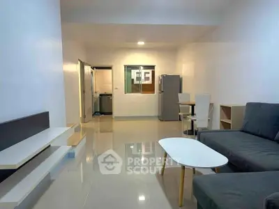 Modern living room with sleek furniture and open layout, featuring a cozy sofa and dining area.