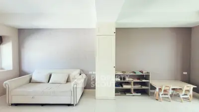 Spacious living room with cozy sofa and children's play area