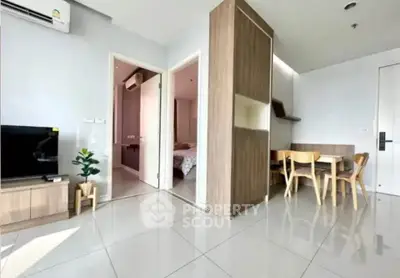 Modern apartment interior with open living and dining area, featuring sleek furniture and natural light.