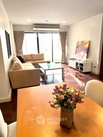 Spacious living room with large windows and elegant decor in modern apartment.