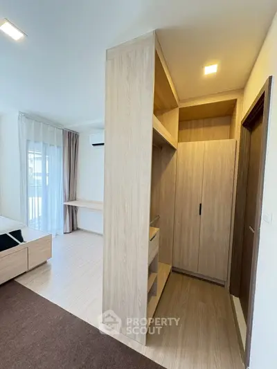 Spacious bedroom with modern wooden wardrobe and natural light
