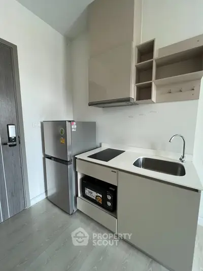 Modern compact kitchen with sleek cabinetry and stainless steel appliances