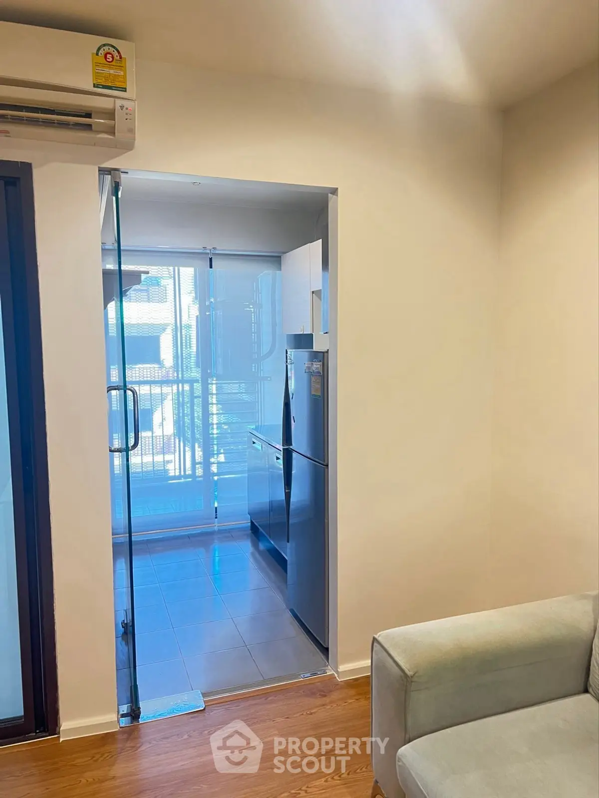 Modern kitchen with glass door and sleek appliances in a cozy apartment setting.