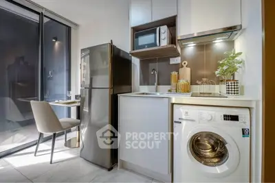 Modern kitchen with sleek appliances and washing machine in stylish apartment