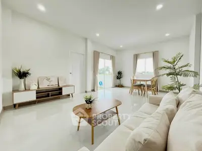 Spacious and bright living room with modern decor and large windows.