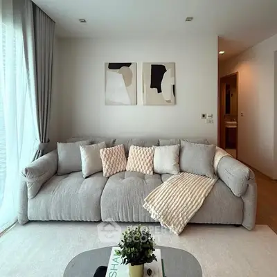 Modern living room with plush gray sofa and abstract art on wall
