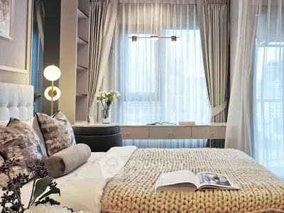 Luxurious bedroom with elegant decor and large window offering city views.