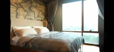 Luxurious bedroom with large window and world map accent wall, offering a serene and stylish retreat.