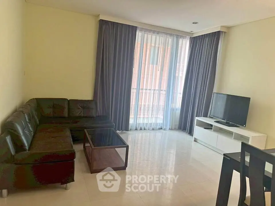 Spacious living room with modern furniture and large window for natural light.