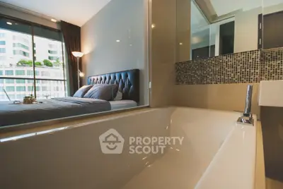 Luxurious bedroom with ensuite bathroom featuring a modern bathtub and elegant decor.