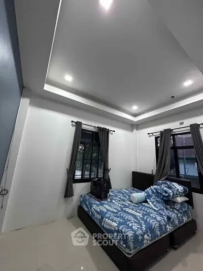 Spacious bedroom with modern design and large windows for natural light.
