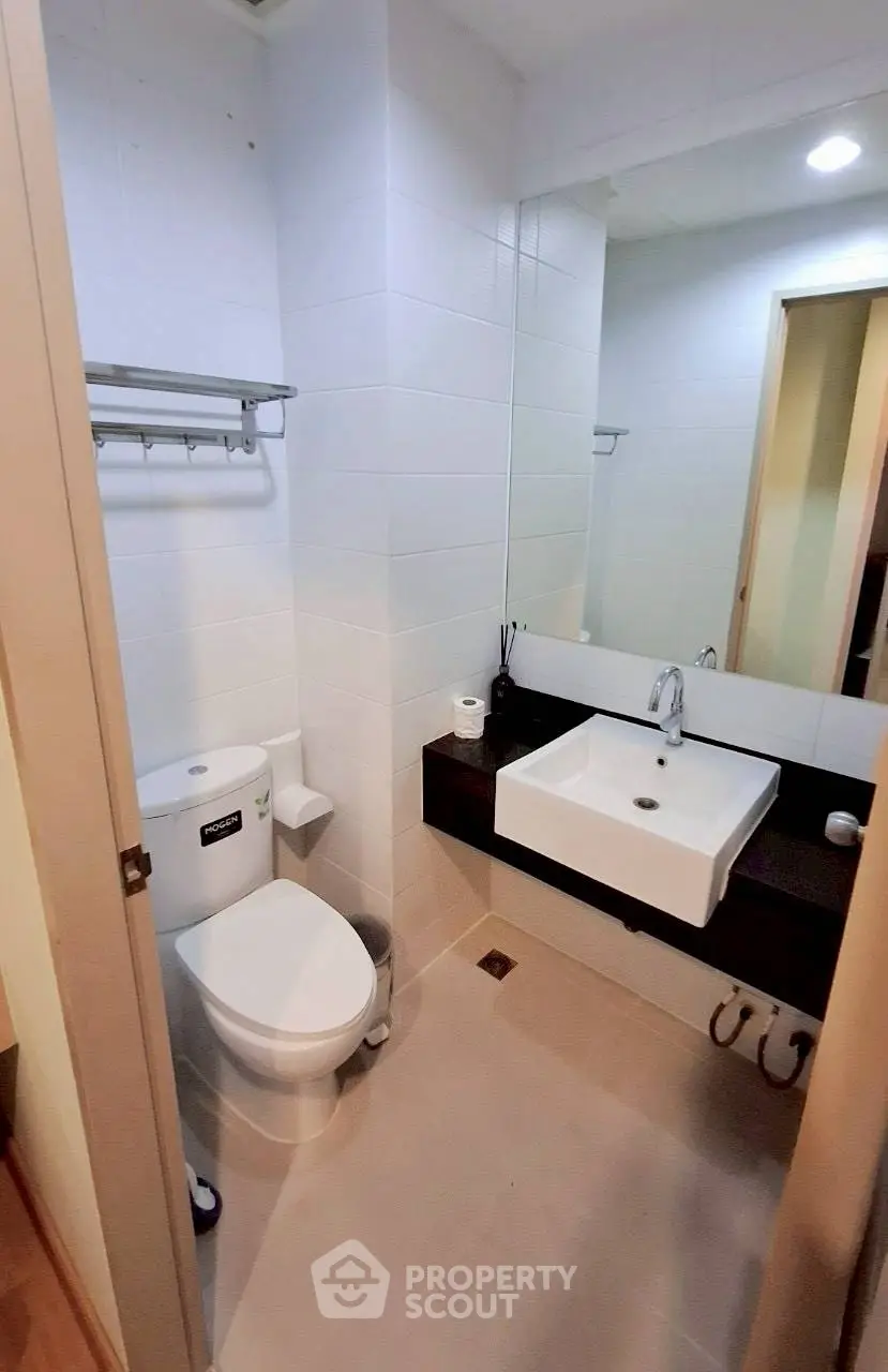 Modern bathroom with sleek fixtures and large mirror in contemporary apartment.