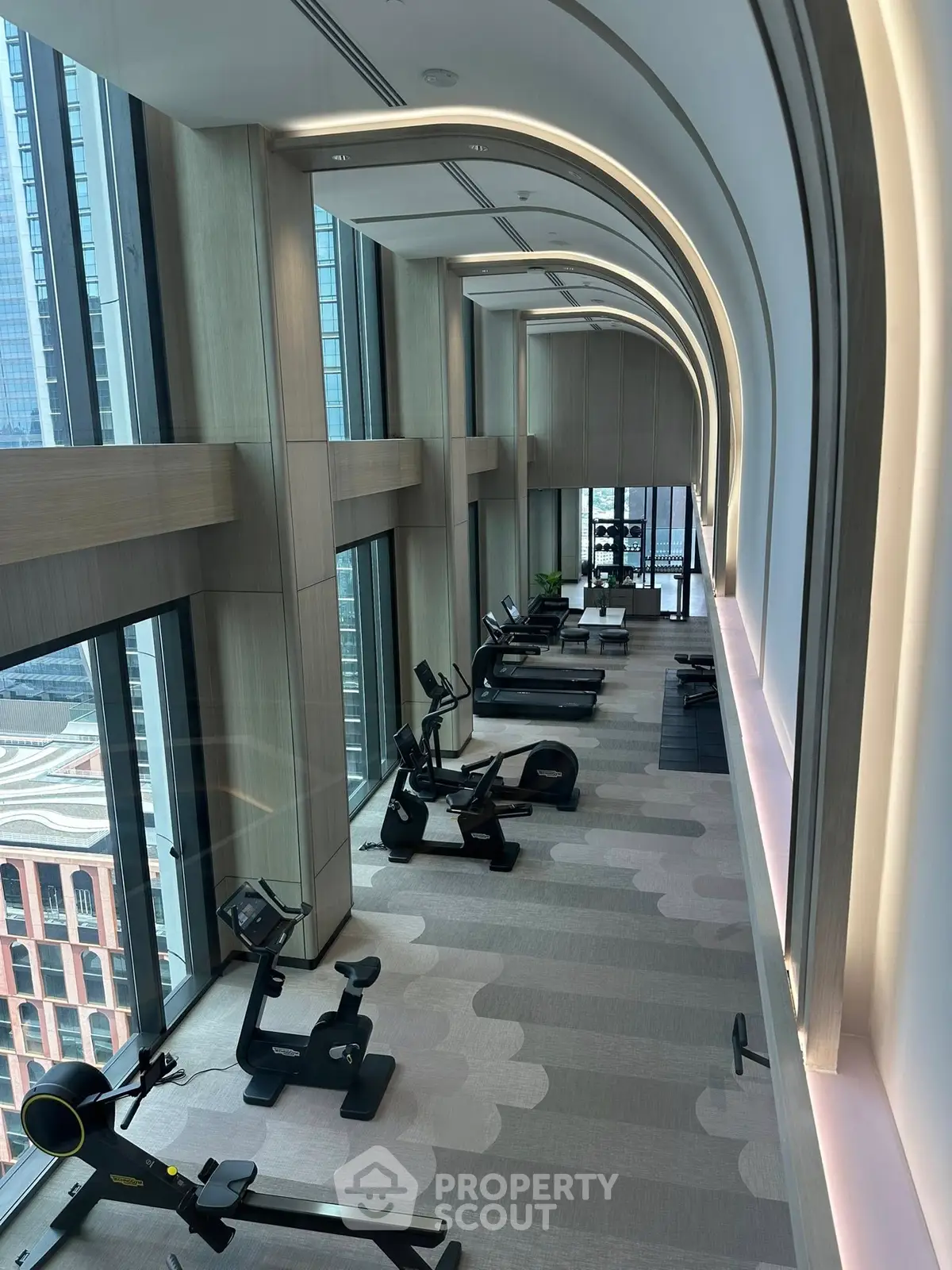 Luxurious high-rise gym with panoramic city views and modern fitness equipment.