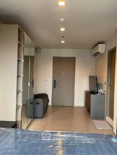 Modern bedroom with mirrored wardrobe and sleek furniture in a stylish apartment.