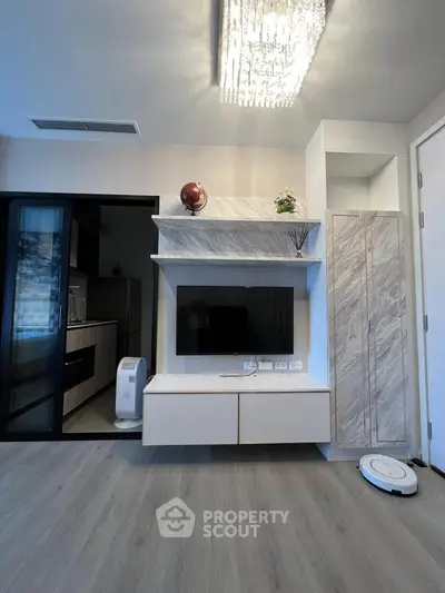 Modern living room with sleek TV unit and elegant lighting, showcasing contemporary interior design.