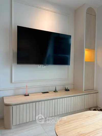 Modern living room with wall-mounted TV and stylish wooden cabinet