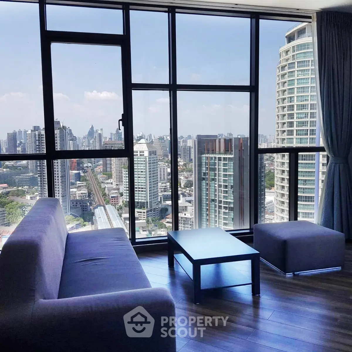 Stunning high-rise living room with panoramic city views and modern furnishings.