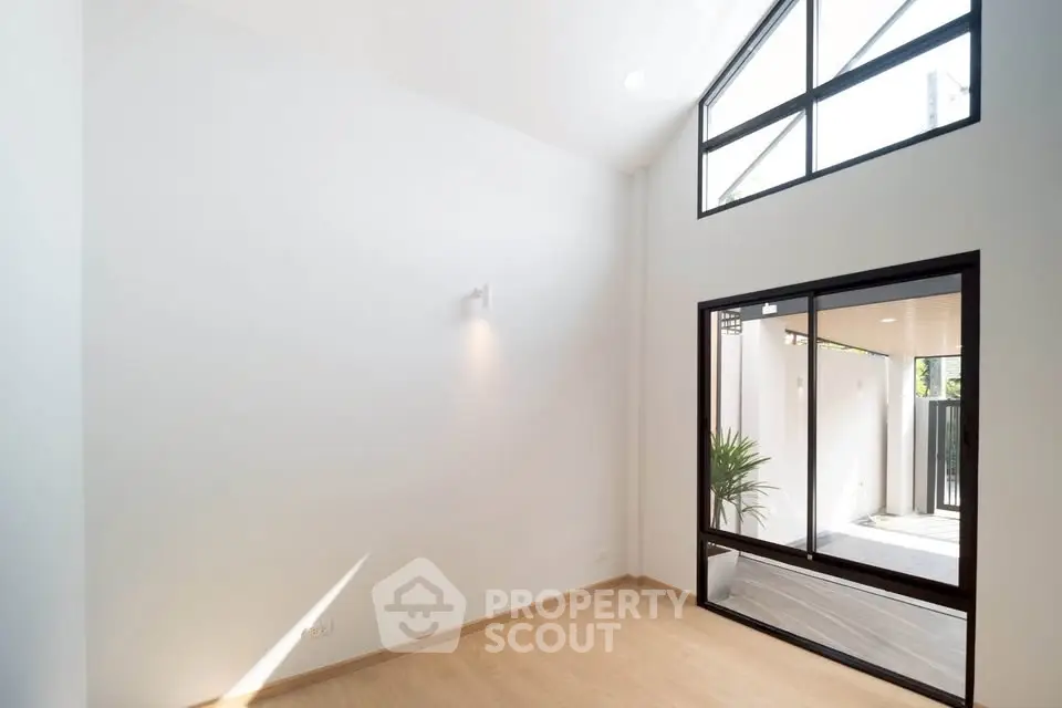 Spacious modern living room with high ceilings and large windows for natural light.