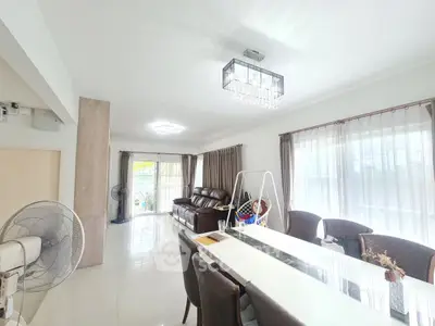 Spacious and bright living room with modern chandelier and elegant dining area.