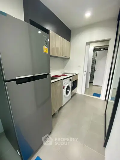 Modern kitchen with sleek appliances and ample storage space in a stylish apartment.