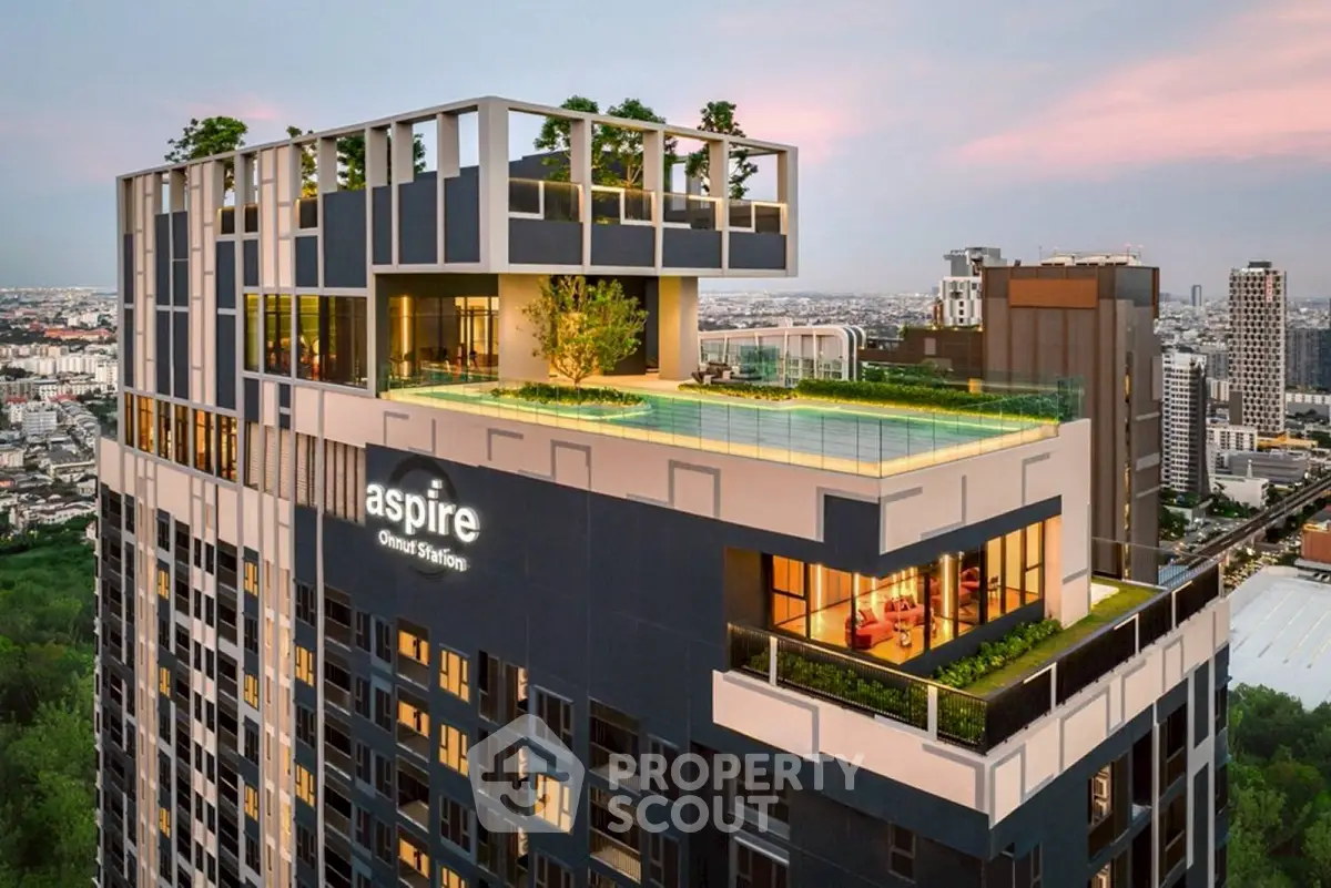 Luxurious high-rise building with rooftop pool and stunning city view at sunset.