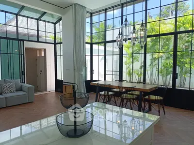 Spacious living room with large windows and elegant dining area in modern home