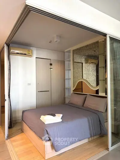 Modern bedroom with sliding glass doors and air conditioning in a stylish apartment.