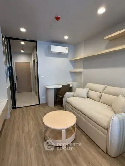 Modern living room with cozy sofa, stylish coffee table, and sleek air conditioning unit.