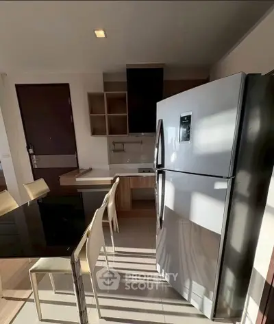 Modern kitchen with sleek refrigerator and dining area in stylish apartment