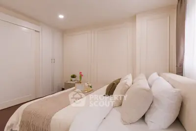 Elegant bedroom with cozy bedding and soft lighting, perfect for relaxation.