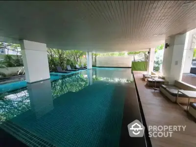 Luxurious indoor pool area with modern design and lush greenery